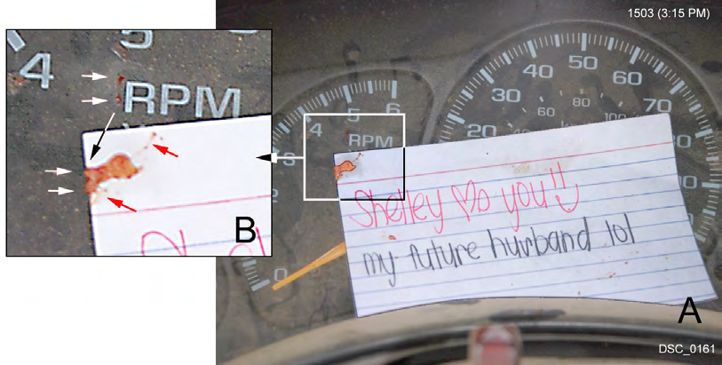 Figure 13: A. The instrument panel love card; the upper corner (in square) is a transfer bloodstain. B. The enlargement of the edge of the card shows the transfer bloodstain, which had an edge accumulation of blood that secondarily transferred to the instrument panel surface (upper pair of white arrows); this occurred at the time the card attained the position shown in Figure 12B. The pattern of the transfer corresponds to under-card edge blood accumulation on the card (at lower pair of white arrows). The bloodstains at the red arrows are associated with the main transfer but had just a small amount of blood transfer.