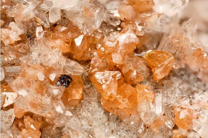 Figure 2: Monazite-(Ce) specimen from Siglo XX mine, Bolivia – the orange mineral is monazite, and the clear one quartz. Geological society of London report 2011.