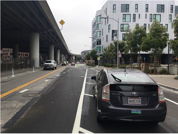 Figure 4: View of bike lane designed to prevent car door opening to injure or impede bicyclists. Parking spaces are now in what was a traffic lane with traffic moving passed parked cars in only lane left.